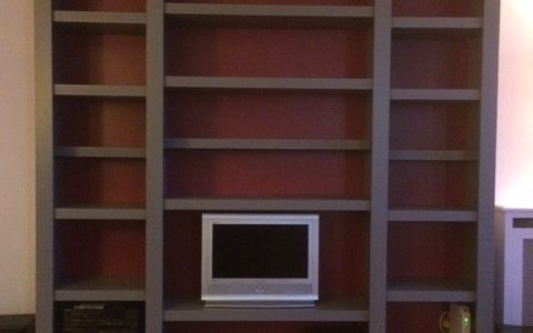 Bibliothèque contemporaine grise à fond rouge