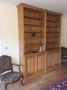 Bibliothèque en bois naturel ouvrante par quatre portes en façade