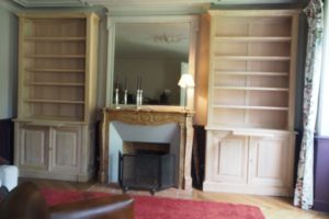 Bibliothèques en châtaignier brut encadrant en cheminée en marbre