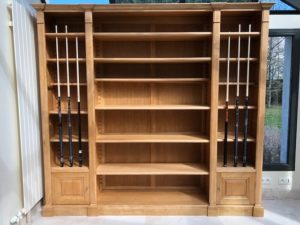 Bibliothèque en bois naturel formant porte queues de billard