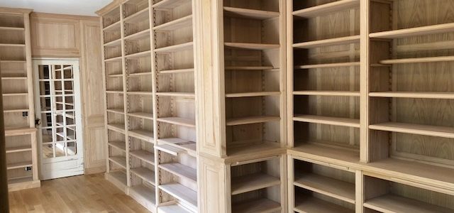 Bibliothèques Néo-Classique en bois naturel recouvrantes la totalité des murs d’une pièce