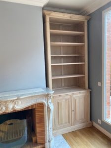 Bibliothèque encadrant une cheminée en marbre