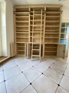 Élégante bibliothèque venant couvrir un pan de mur dans un salon