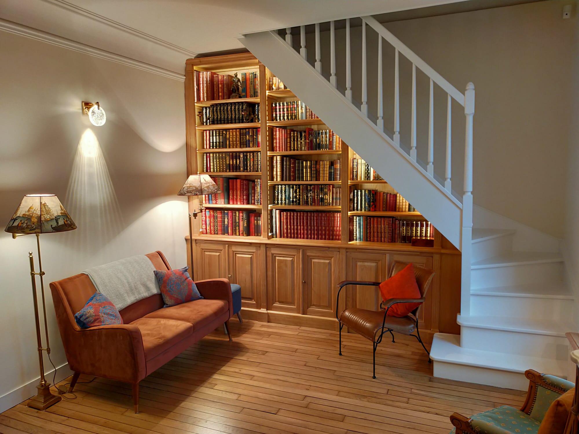 Bibliothèque intemporelle en bois naturel sous un escalier