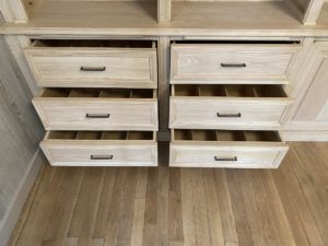 Bibliothèque de parquet en bois naturel venant coffrer un large conduit de cheminée