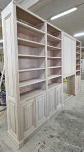 Bibliothèques intemporelle en bois naturel encadrant une cheminée en marbre vert de mer d’époque XIX eme