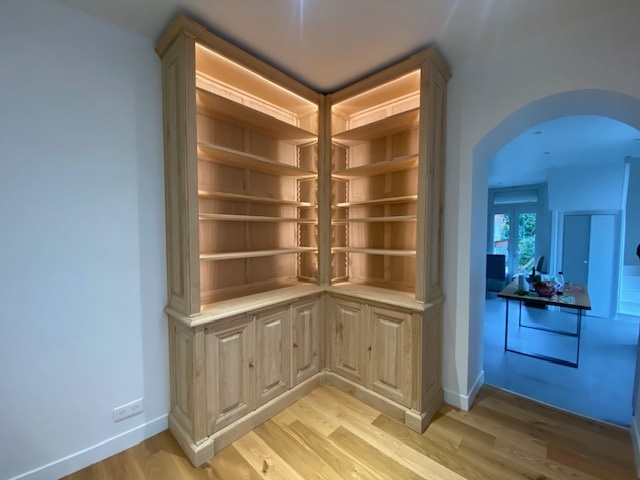 Bibliothèque d’angle ouvrant en façade par cinq portes en partie basse en bois de châtaignier