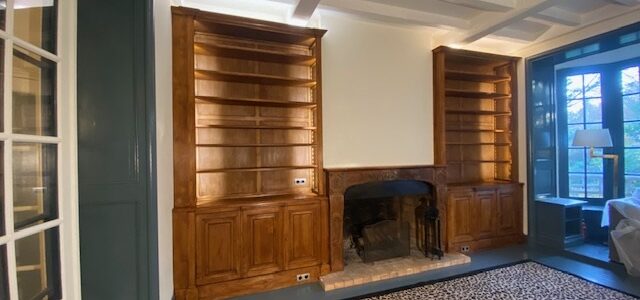 Paire de bibliothèques en bois naturel venant encadrer une cheminée d’époque XVIIIe