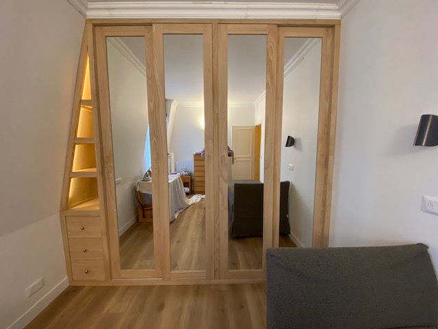 Dressing contemporain en bois naturel sous toiture mansardée