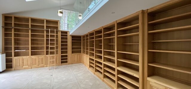 Bibliothèques en bois naturel venant s’implanter sur près de Seize mètres de longueur de murs