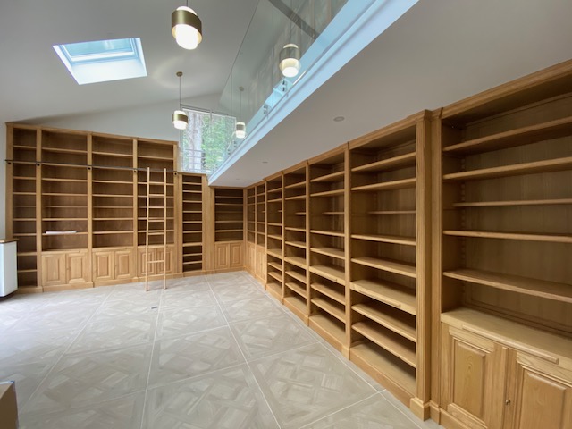 Bibliothèques en bois naturel venant s'implanter sur près de Seize mètres de longueur de murs