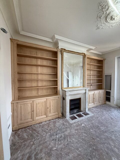 Paire de bibliothèques Parisiennes en bois naturel venant encadrer une cheminée en marbre